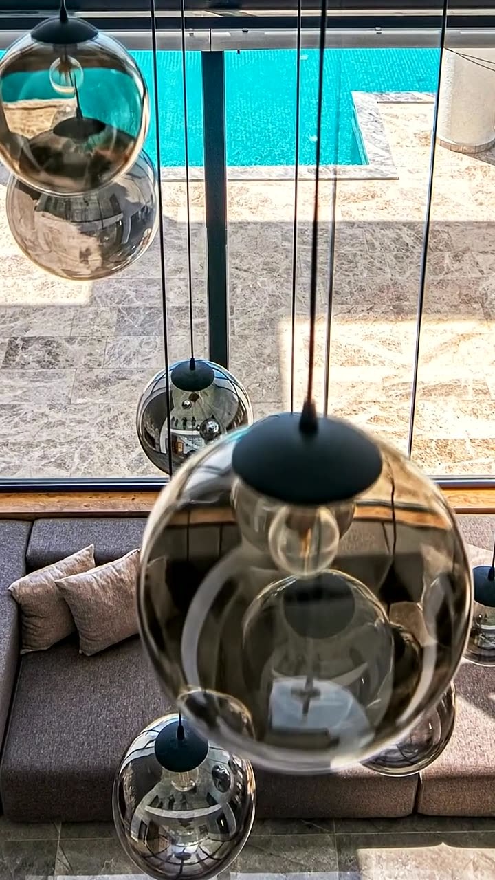 Salón con lámparas de cristal y vistas a la piscina